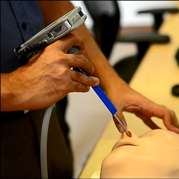 Doctor inserting medical device in the nose of an artificial head model